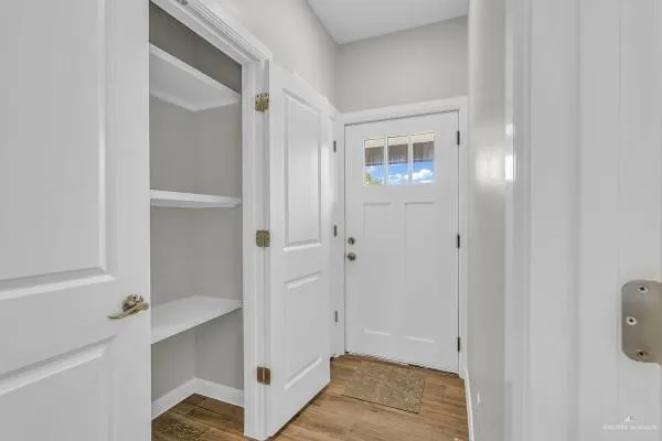a view of a hallway with closet and a bathroom