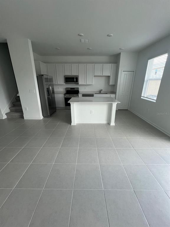 2660 Skyline Loop Kissimmee, FL 34758 - Photo 5 of 19 a kitchen with stainless steel appliances a refrigerator a sink a stove a microwave and cabinets