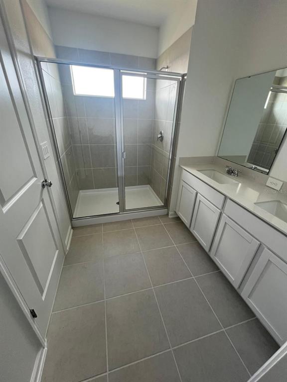 2660 Skyline Loop Kissimmee, FL 34758 - Photo 7 of 19 a bathroom with a glass door shower a sink and a mirror
