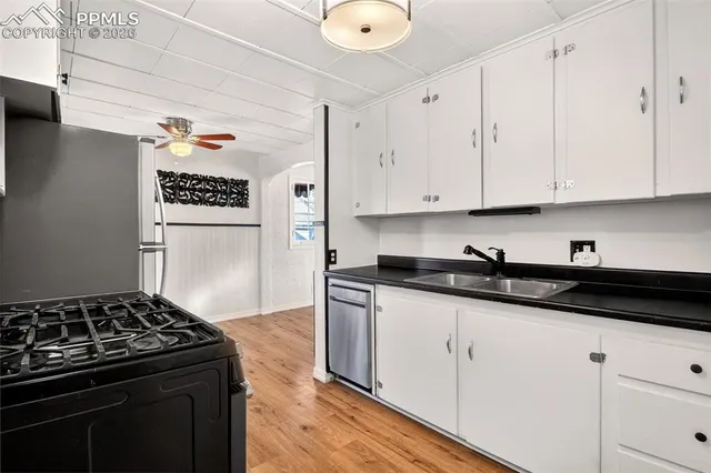 a kitchen with granite countertop a sink a stove and cabinets