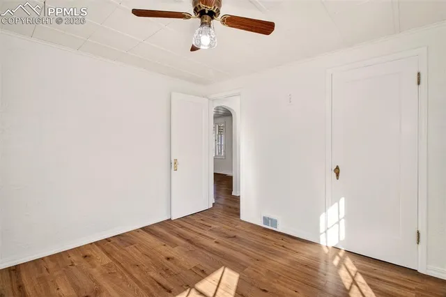 a view of empty room with wooden floor