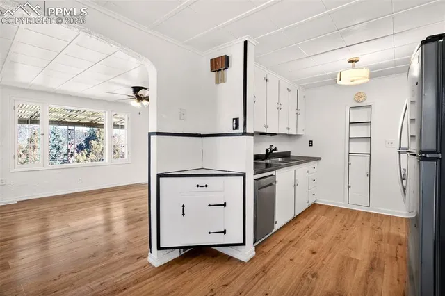 a kitchen with granite countertop white cabinets and white appliances