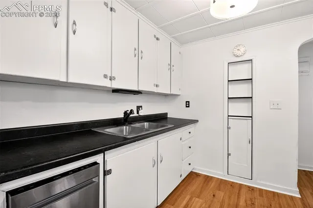 a kitchen with granite countertop white cabinets and a sink