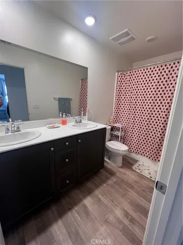 a bathroom with a double vanity sink mirror and toilet