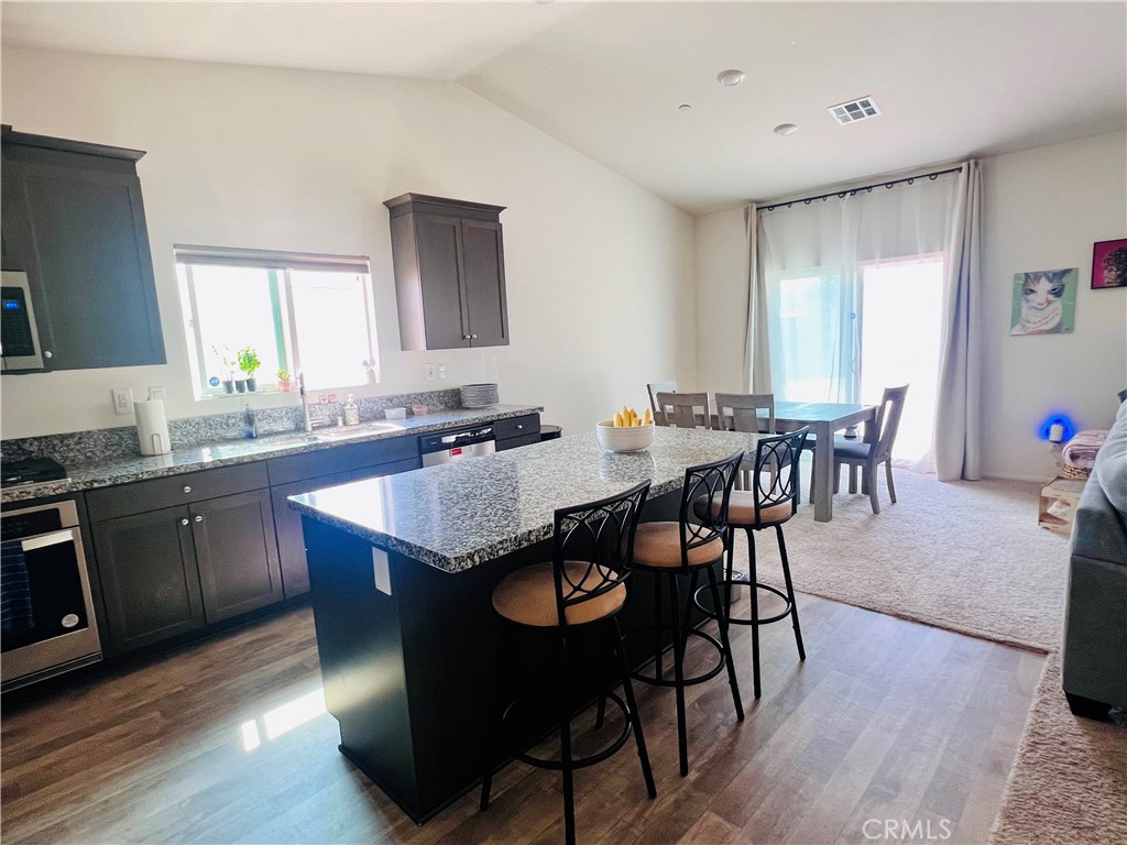 31381 Linden Flower Road Winchester, CA 92596 - Photo 5 of 33 a kitchen with granite countertop a dining table chairs and wooden floor