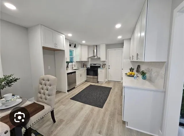 a kitchen with stainless steel appliances granite countertop a refrigerator and a stove top oven