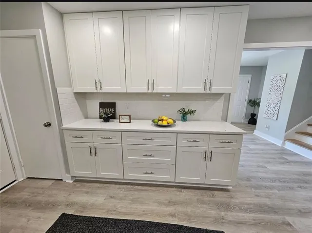 a kitchen with white cabinets and sink