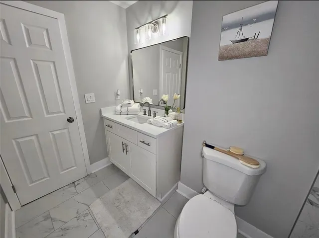 a bathroom with a toilet sink and mirror