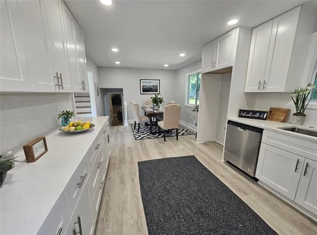 a kitchen with sink refrigerator and wooden floor