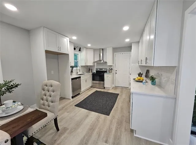 a kitchen with stainless steel appliances granite countertop a refrigerator and a stove top oven