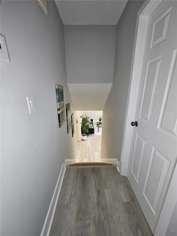a view of a hallway with wooden floor and entryway