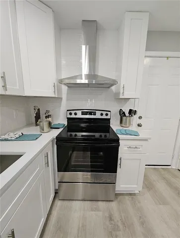 a kitchen with a stove and white cabinets