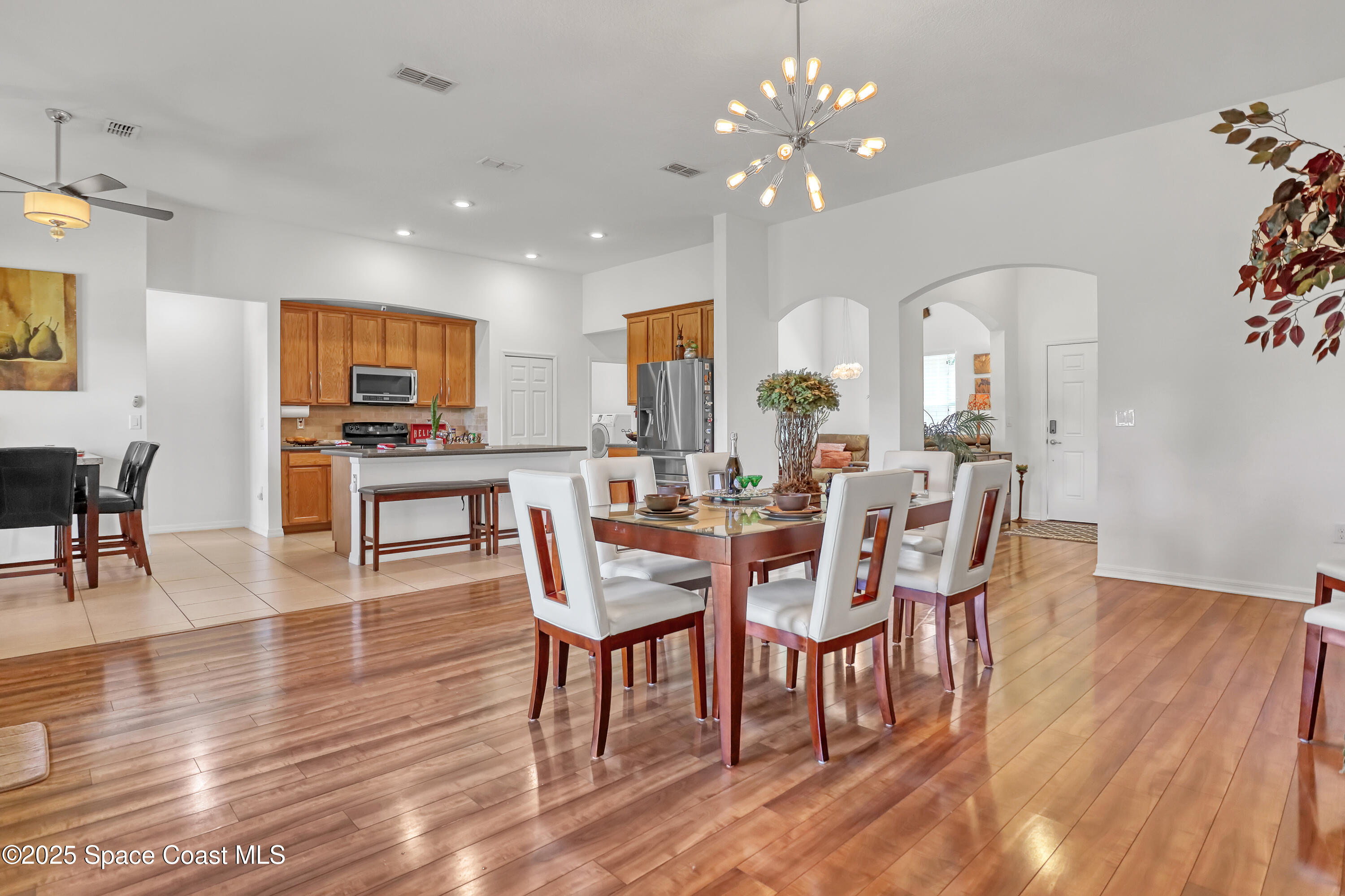 1121 Morgan Circle Northeast Palm Bay, FL 32905 - Photo 17 of 61 a dining room with furniture a chandelier and wooden floor