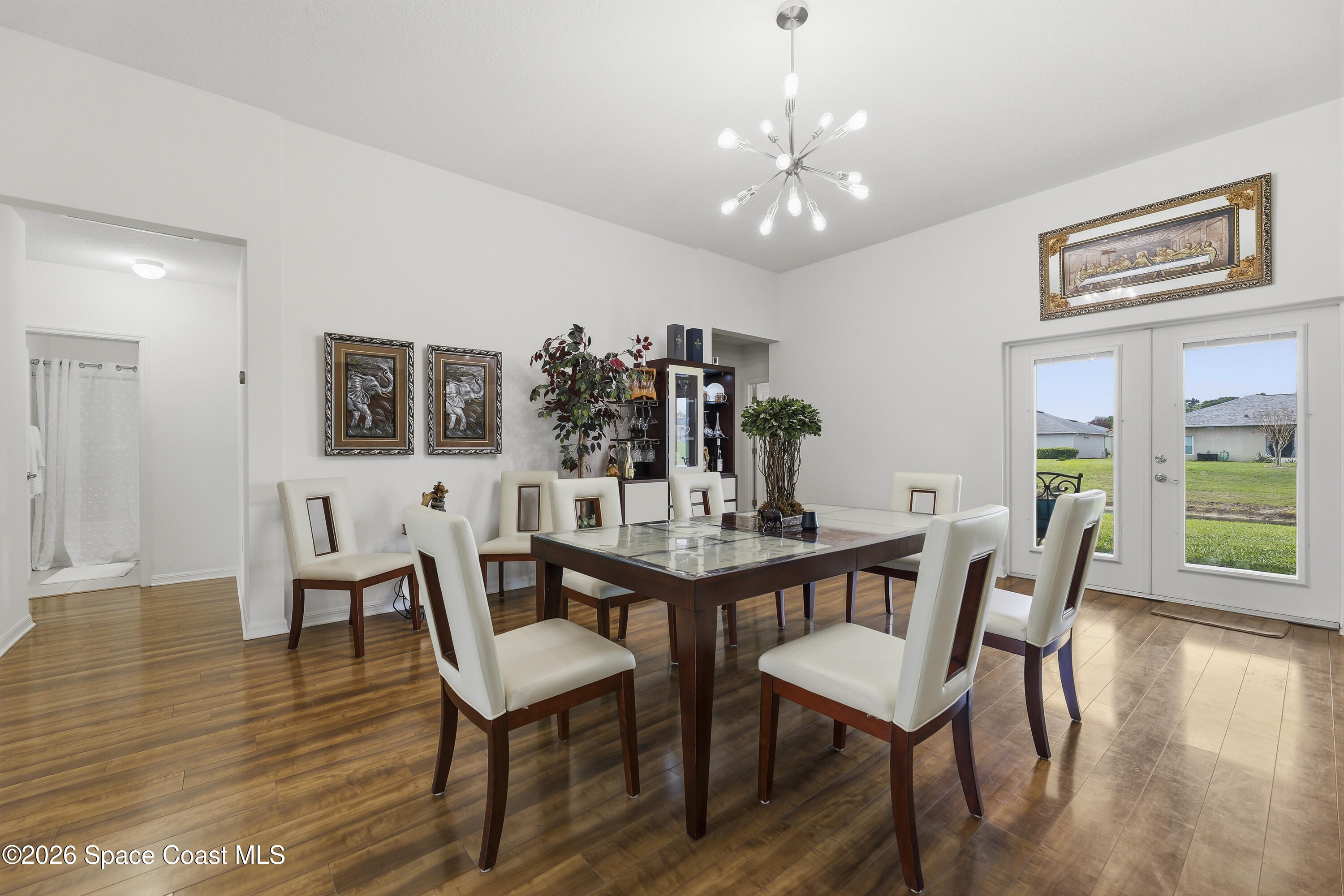 1121 Morgan Circle Northeast Palm Bay, FL 32905 - Photo 25 of 115 a view of a dining room with furniture wooden floor and a chandelier