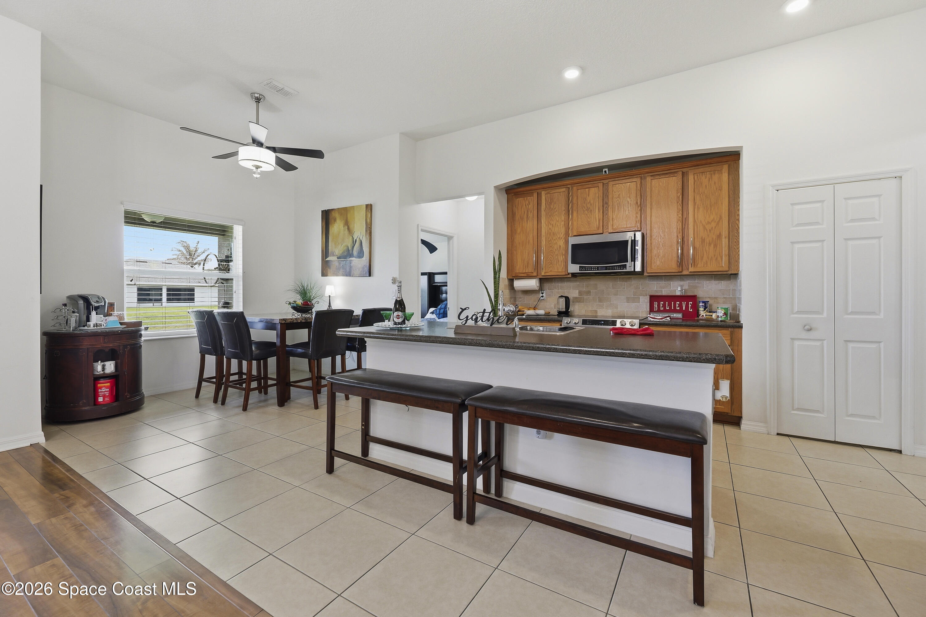 1121 Morgan Circle Northeast Palm Bay, FL 32905 - Photo 40 of 115 a living room with stainless steel appliances kitchen island granite countertop furniture and a flat screen tv