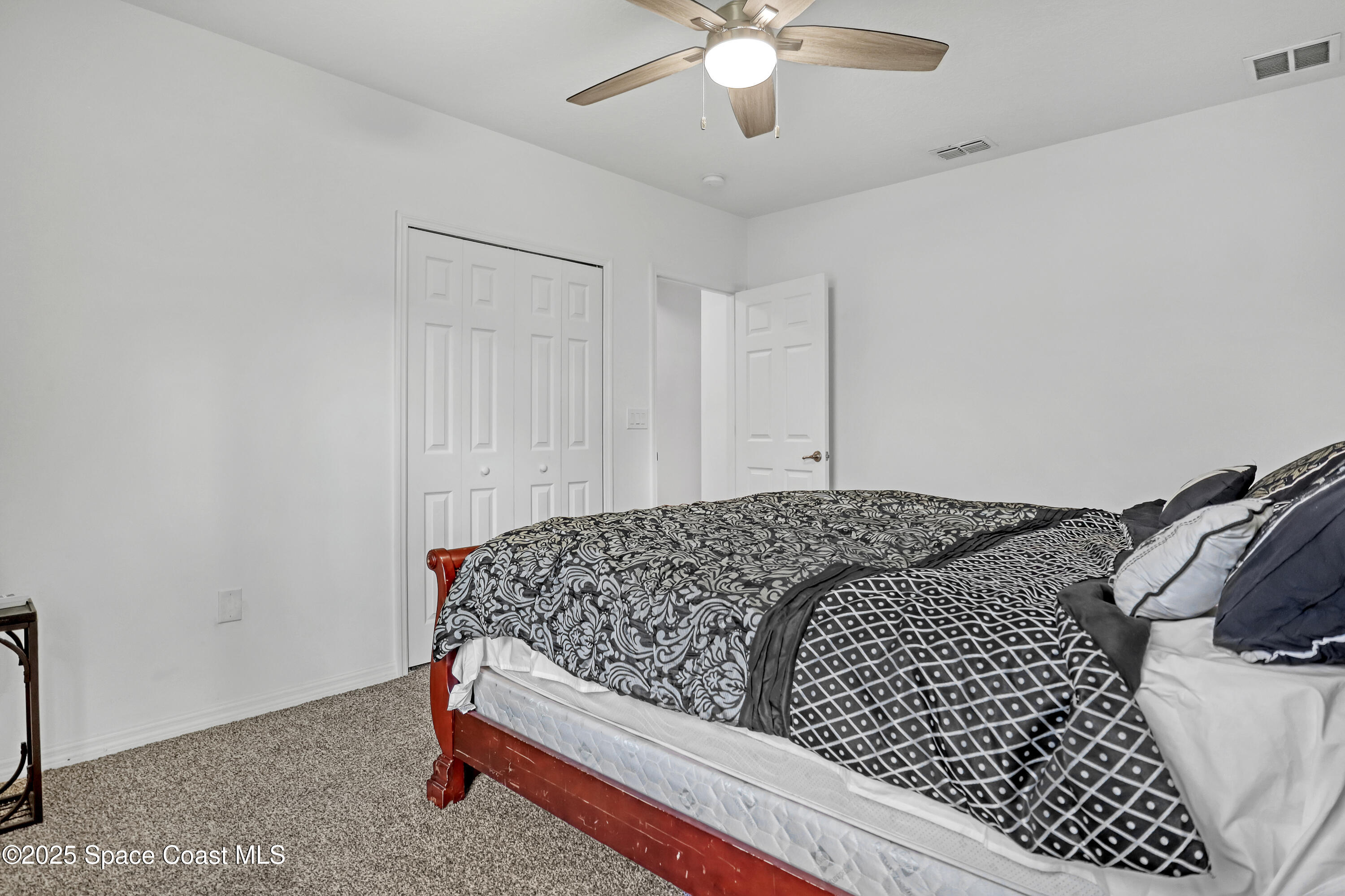 1121 Morgan Circle Northeast Palm Bay, FL 32905 - Photo 43 of 64 a bedroom with a bed and a chandelier