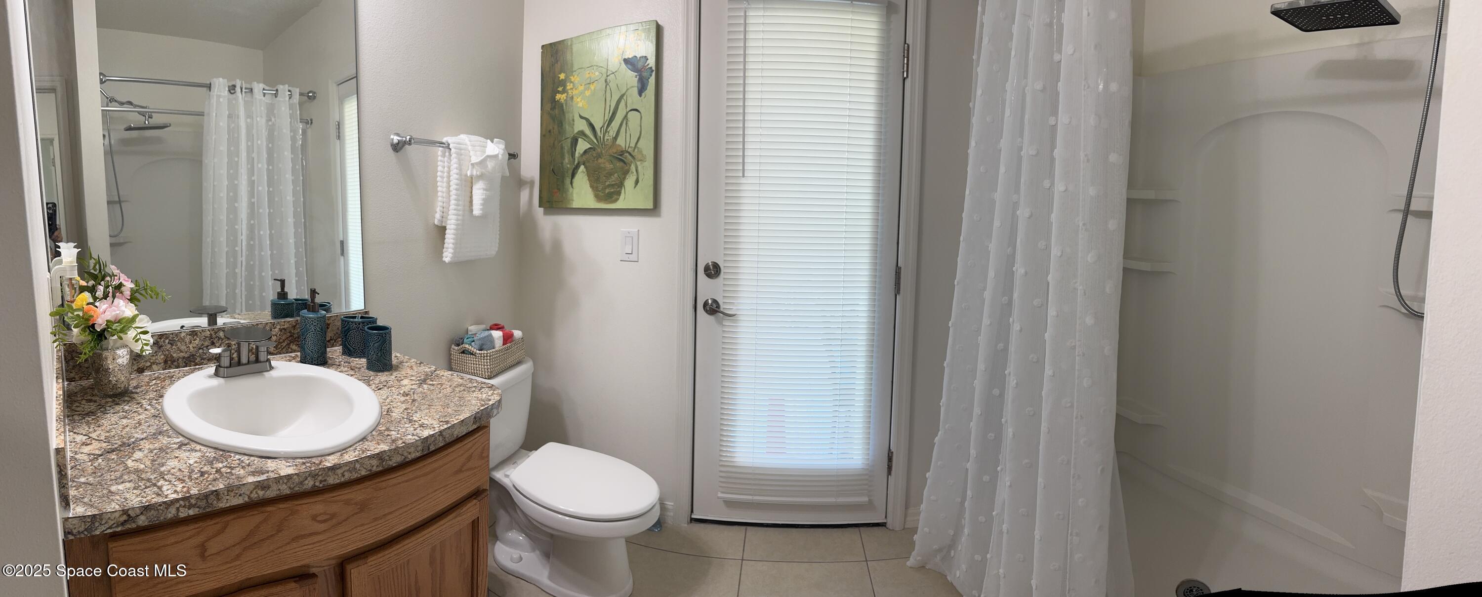 1121 Morgan Circle Northeast Palm Bay, FL 32905 - Photo 44 of 64 a bathroom with a granite countertop sink toilet and shower