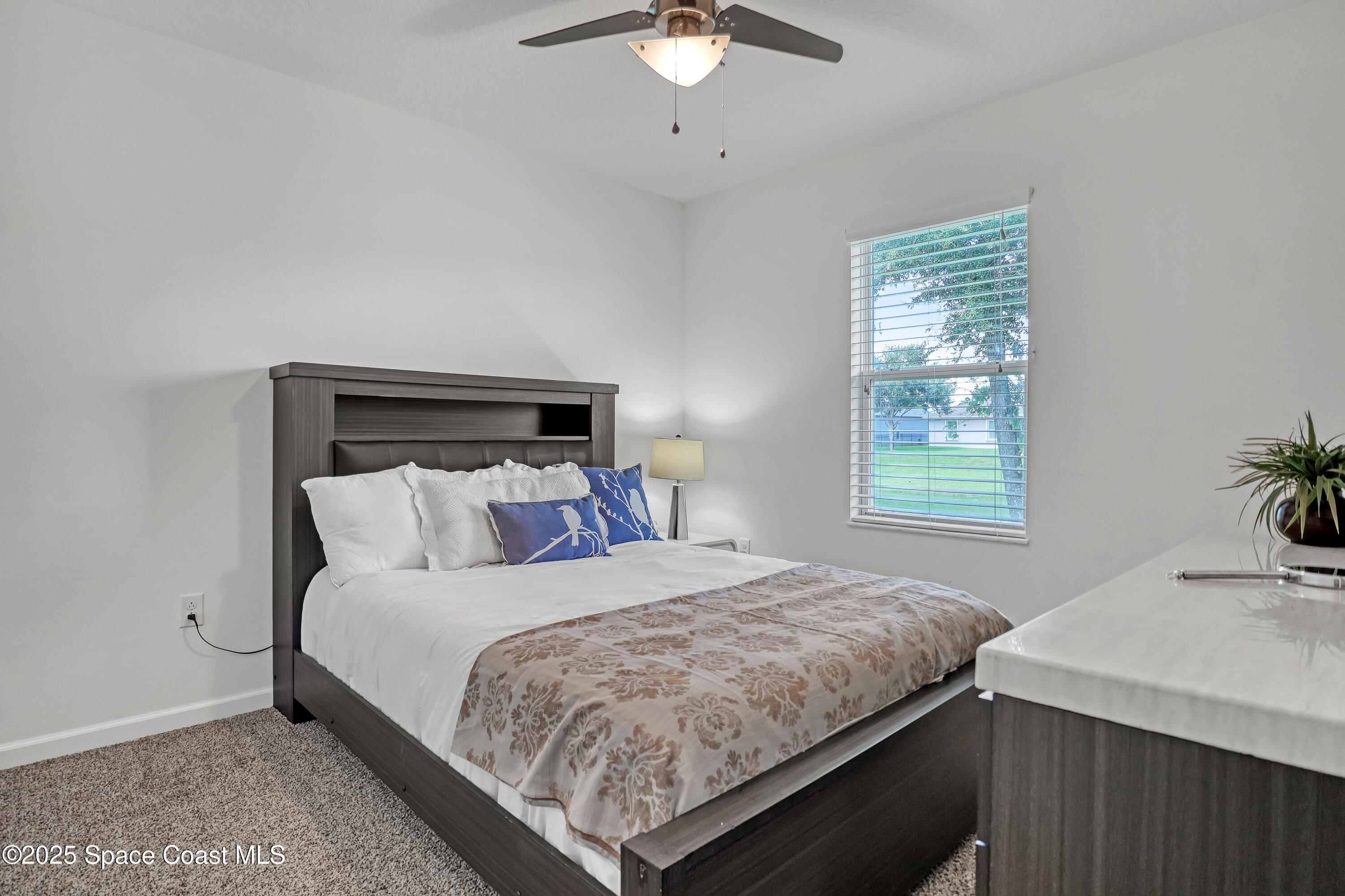 1121 Morgan Circle Northeast Palm Bay, FL 32905 - Photo 47 of 64 a bedroom with a bed and a chandelier