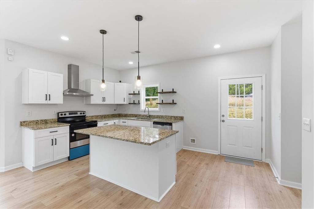 119 Jackson Street Cedartown, GA 30125 - Photo 12 of 58 a kitchen with stainless steel appliances granite countertop a stove a sink and white cabinets with wooden floor