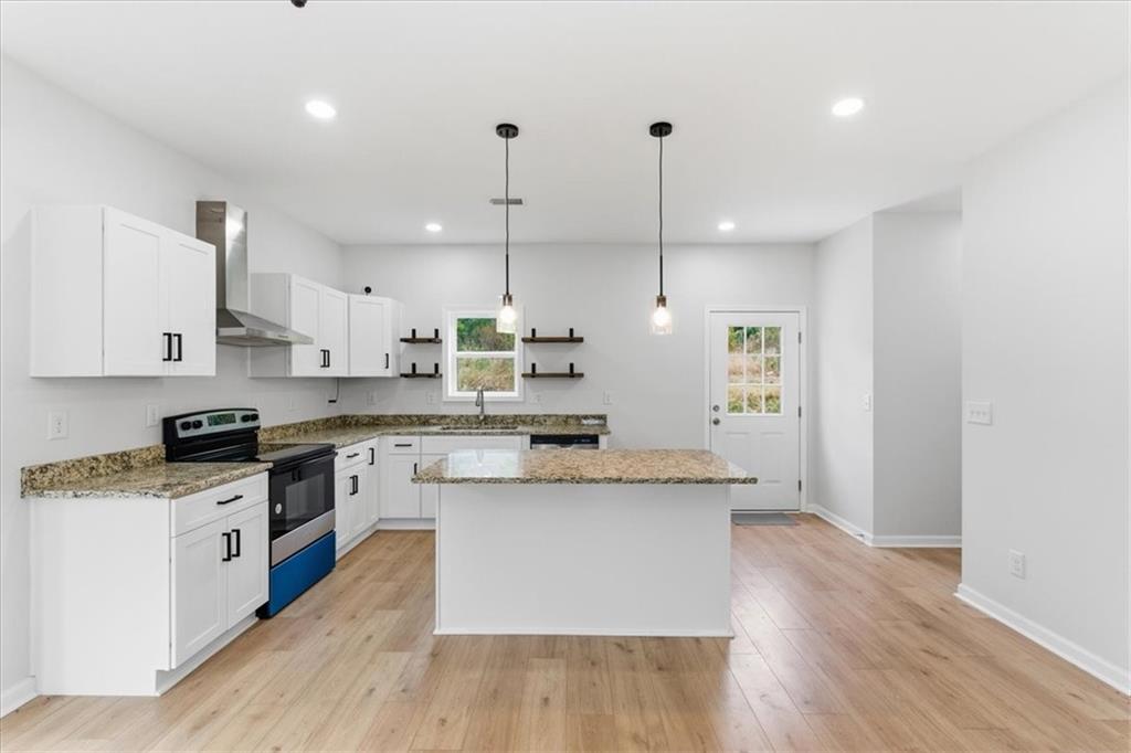 119 Jackson Street Cedartown, GA 30125 - Photo 14 of 58 a large kitchen with stainless steel appliances kitchen island granite countertop a stove a sink a refrigerator and white cabinets with wooden floor