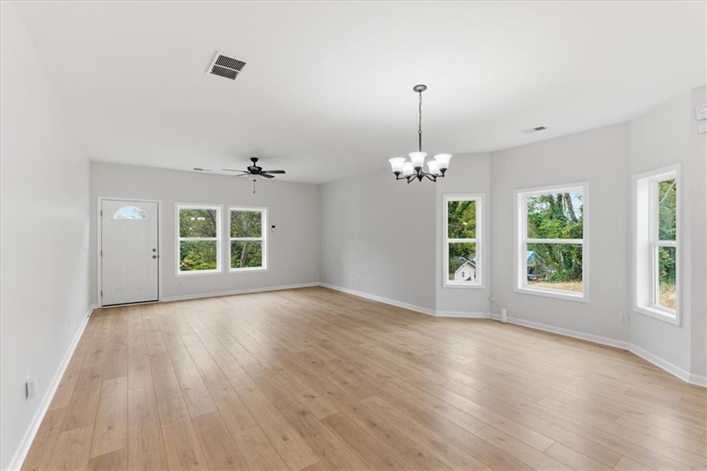 119 Jackson Street Cedartown, GA 30125 - Photo 6 of 58 an empty room with wooden floor chandelier and windows