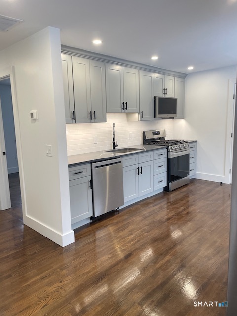 1 Cedar Road Danbury, CT 06811 - Photo 17 of 24 a large kitchen with stainless steel appliances granite countertop a stove a sink and a microwave