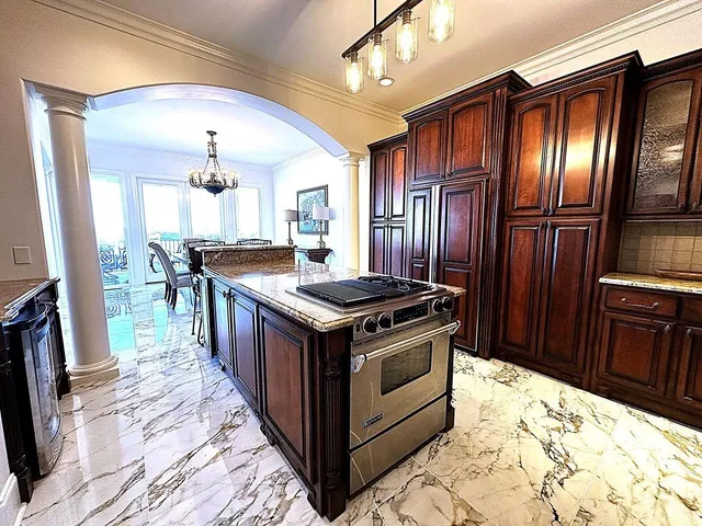 a kitchen with stainless steel appliances granite countertop a stove a refrigerator and wooden cabinets