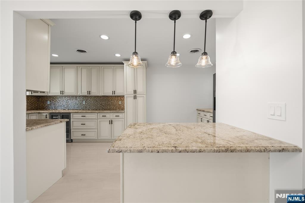 181 Haddenfield Road Clifton, NJ 07013 - Photo 11 of 34 a kitchen with kitchen island a counter top a stove a sink and a refrigerator