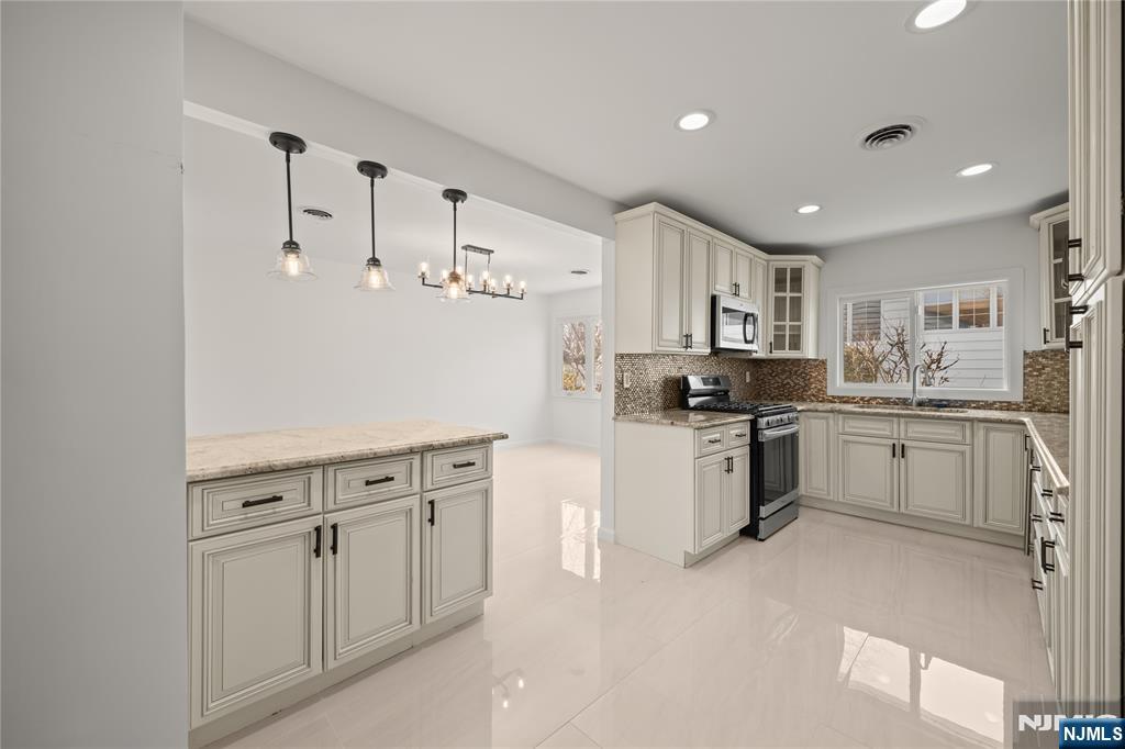 181 Haddenfield Road Clifton, NJ 07013 - Photo 8 of 34 a kitchen with white cabinets and white appliances