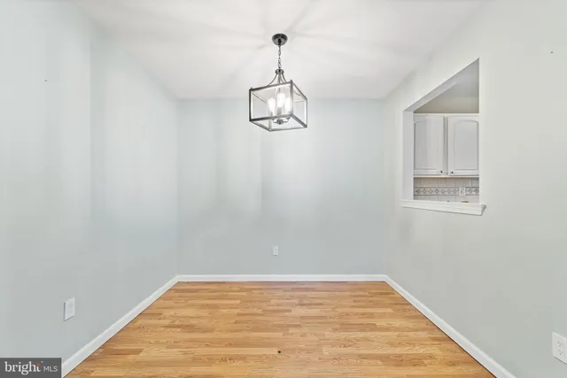 a view of a room with wooden floor and ceiling fan