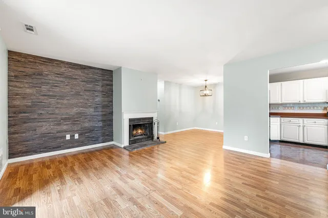 a view of empty room with wooden floor and fireplace