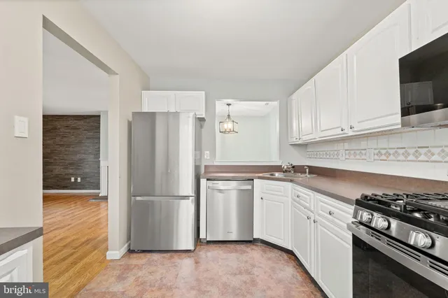 a kitchen with granite countertop a refrigerator and a stove top oven