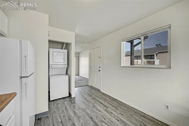 a view of kitchen with refrigerator cabinets and wooden floor