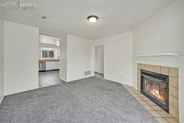a view of an empty room with window and fireplace
