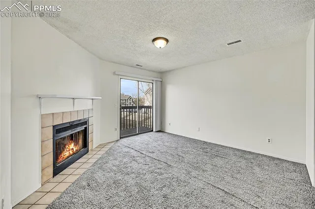 a view of an empty room with a fireplace and a window
