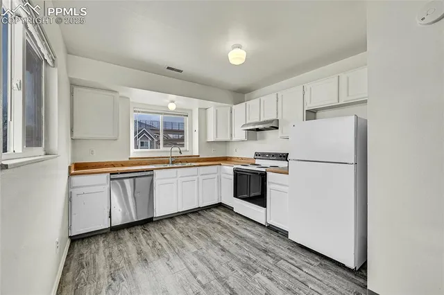 a kitchen with granite countertop white cabinets and white appliances