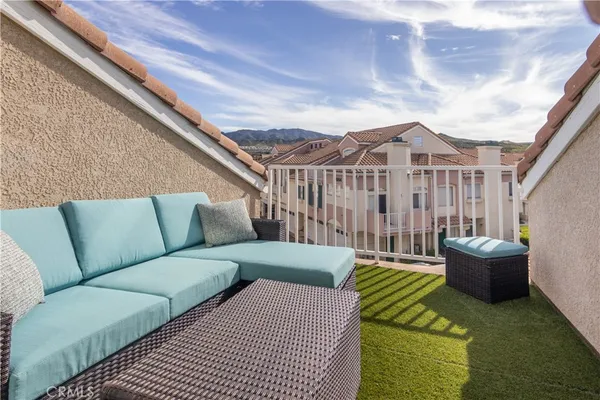 a balcony with furniture and a potted plant