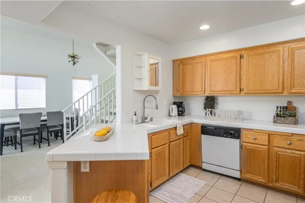a kitchen with a sink a stove cabinets dining table and chairs