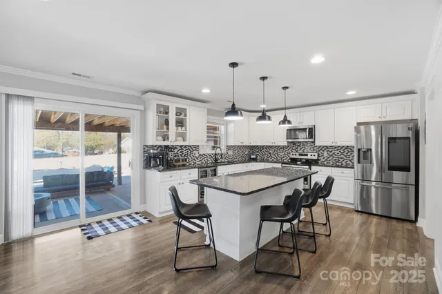 a kitchen with a table chairs refrigerator and microwave