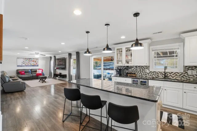 a kitchen with stainless steel appliances granite countertop a stove a sink and a wooden cabinets