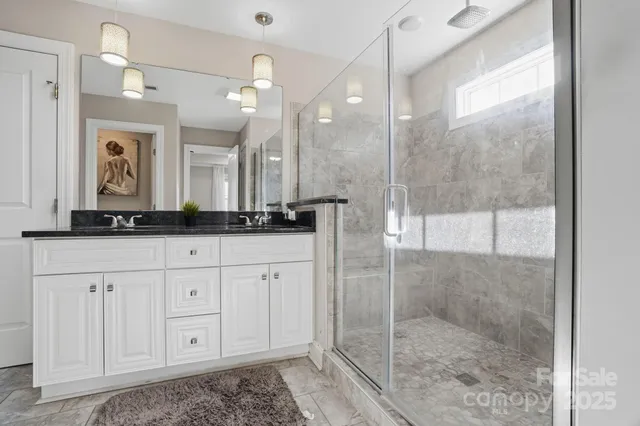 a bathroom with a shower sink and mirror