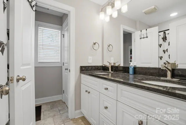 a bathroom with a granite countertop sink a mirror and a shower