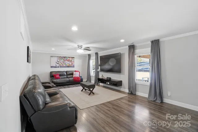 a living room with furniture a flat screen tv and a window