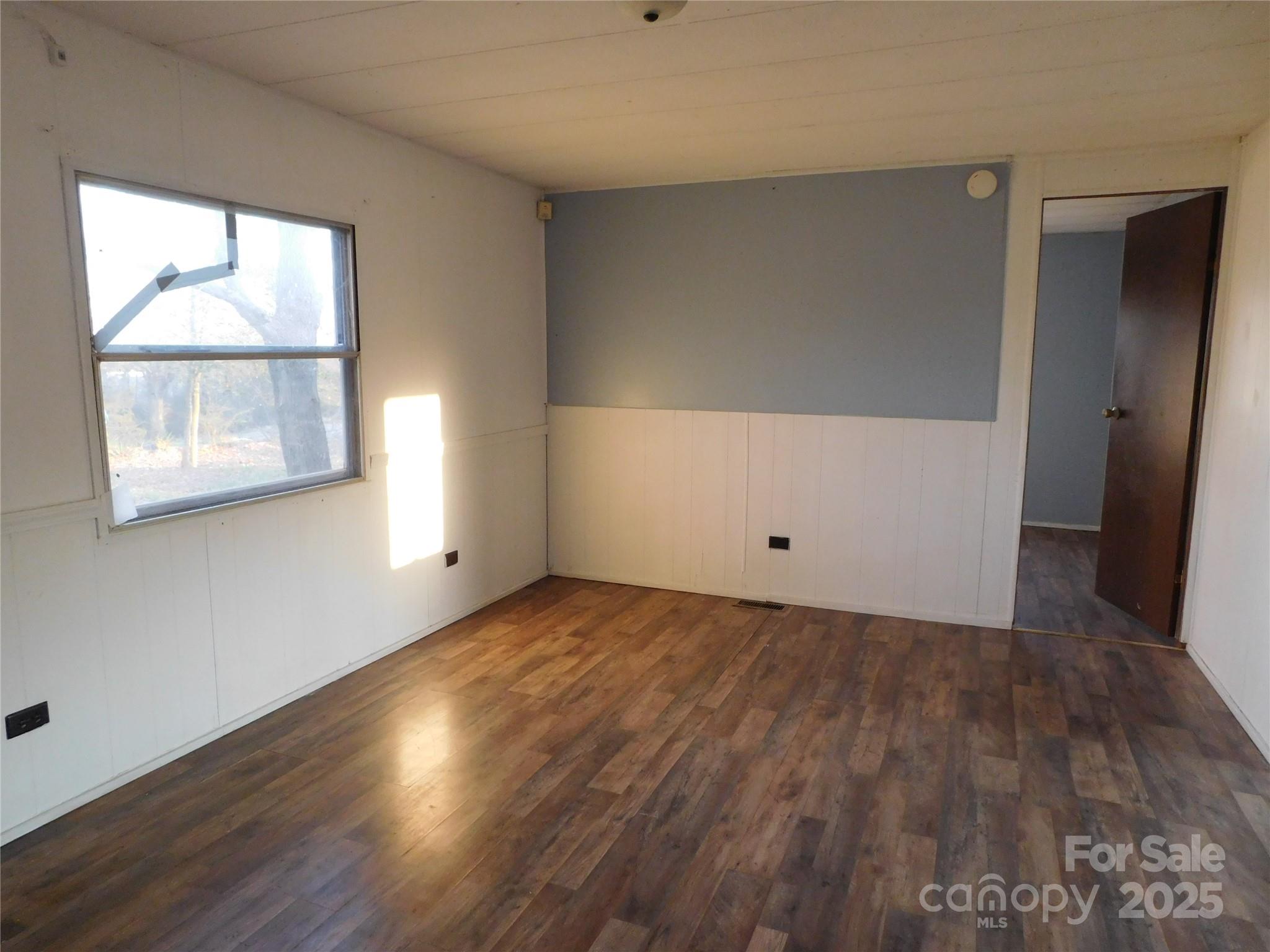 3028 Austin Chaney Road Monroe, NC 28110 - Photo 11 of 16 an empty room with wooden floor and windows