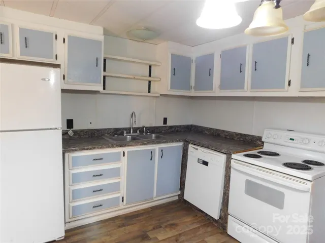 a kitchen with granite countertop white cabinets and white appliances