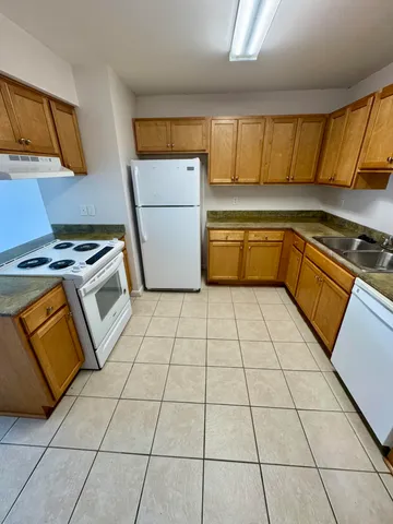 a kitchen with stainless steel appliances a stove a sink and a refrigerator