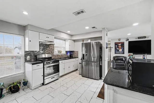 a kitchen with stainless steel appliances granite countertop a refrigerator stove microwave and sink