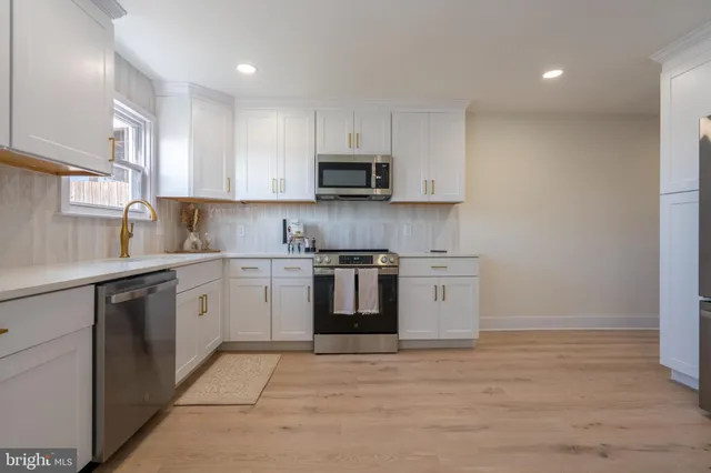 a kitchen with a stove top oven sink and cabinets