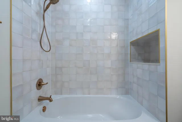 a bathroom with a bath tub with a shower