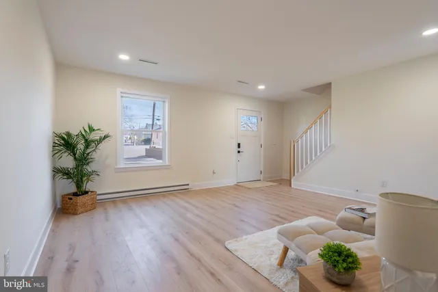 a view of an empty room with wooden floor and a potted plant